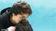 a man and a woman are kissing in front of a blue wall .