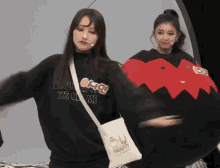 a girl wearing a black sweatshirt that says " it 's me "