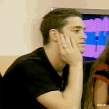 a man with a ring on his finger is covering his face