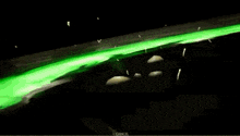 a pile of skulls are surrounded by green smoke and glowing green lights .