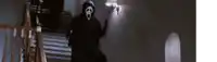 a person wearing a scream mask is walking down stairs .