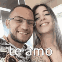 a man and a woman are posing for a picture and the woman is smiling .
