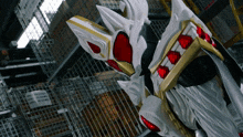 a white and gold robot with red eyes is standing in a room