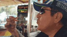 a man wearing a hat that says yamaha factory eating a snack