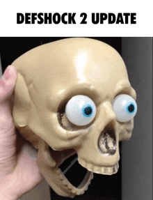 a person is holding a skull with big eyes and the words defshock 2 update above it
