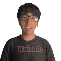 a young man wearing glasses and a black shirt that says kaizen