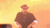a man wearing a hat and headphones is dancing in front of a coca cola sign .