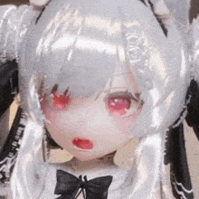 a close up of a doll with white hair and red eyes