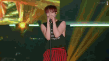 a man singing into a microphone while wearing a black tank top that says i love you