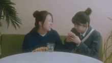two girls sitting at a table with one wearing a sweatshirt that says california on it