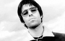 a man wearing sunglasses and a jacket is looking at the camera .