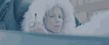 a woman wearing a white fur coat has a ring on her finger that reads az