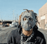 a man wearing a chain around his neck and a mask on his head