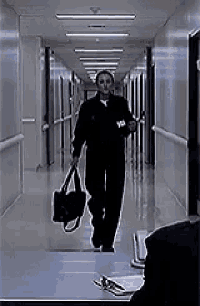 a man is walking down a hallway with a bag in his hand