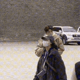 a man wearing a face mask is standing next to a woman wearing a mask .
