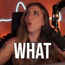 a woman is sitting in front of a microphone making a funny face .