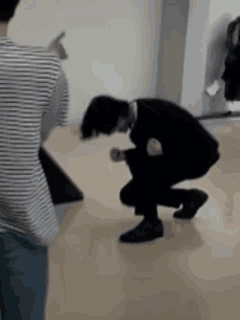 a man in a striped shirt is kneeling down
