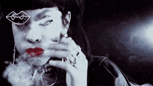 a woman is smoking a cigarette with a drawing of a kiss on her face .