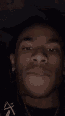 a close up of a young man 's face with his hand on his head .