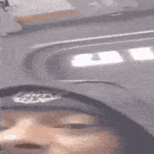 a blurry picture of a person wearing a hat that says ' sdc ' on it