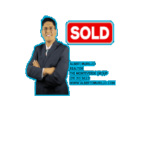 a man with his arms crossed stands in front of a sold sign