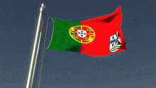 two flags are waving in the wind one of which has the word portugal on it