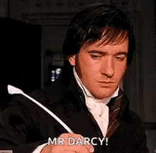 a man in a suit and tie is writing with a quill pen .
