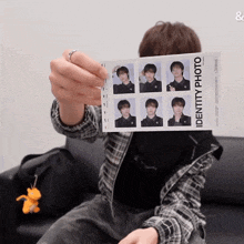 a man is holding up a identity photo