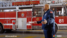 a man stands in front of a chicago fire dept truck number 81