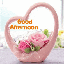 a heart shaped vase filled with pink roses and the words `` good afternoon ''