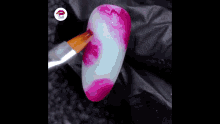 a close up of a nail being painted with a brush