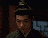 a close up of a man wearing a traditional costume and a bun .