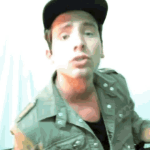 a man wearing a hat and a vest is making a face
