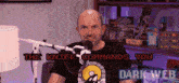 a man is sitting in front of a microphone with the words " the knife commands you " on the bottom right