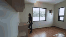 a woman stands in an empty room with the words made in animatica on the bottom
