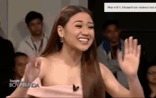 a woman in a pink dress is smiling and waving in front of a screen that says tonight with boy abunda