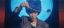 a man wearing a purple hat is holding a necklace in his hand