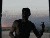 a man without a shirt is standing in the dark