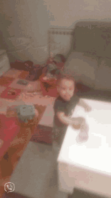 a little boy is sitting on a couch in a room