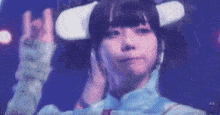 a young girl wearing a virtual reality headset is making a peace sign .