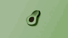 an avocado with a hole in the middle is on a green background