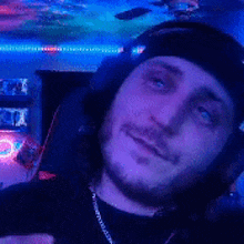 a man wearing headphones and a headband is taking a selfie in a dark room