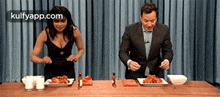 a man and a woman are sitting at a table with plates of food .
