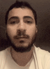 a man with a beard is wearing a white t-shirt