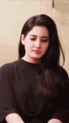 a woman with long hair is wearing a black shirt and red lipstick .