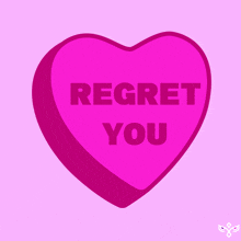 a pink heart shaped candy that says regret you