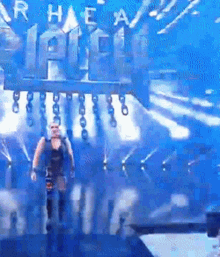 a man is walking on a stage in front of a sign that says r.h.e.a.