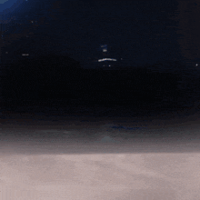 a dark sky with a few lights visible in the distance