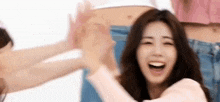 a woman in a pink shirt is giving a high five to another woman .