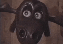 a close up of a moose statue with a wooden background